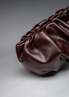 Brown leather handbag on a gray background
