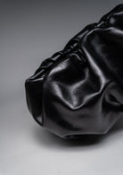 Black leather handbag on a gray background
