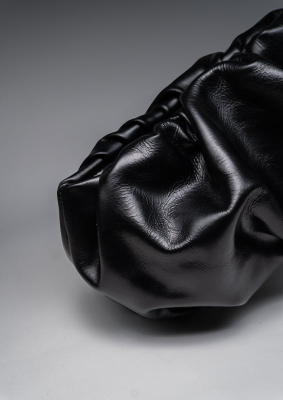 Black leather handbag on a gray background